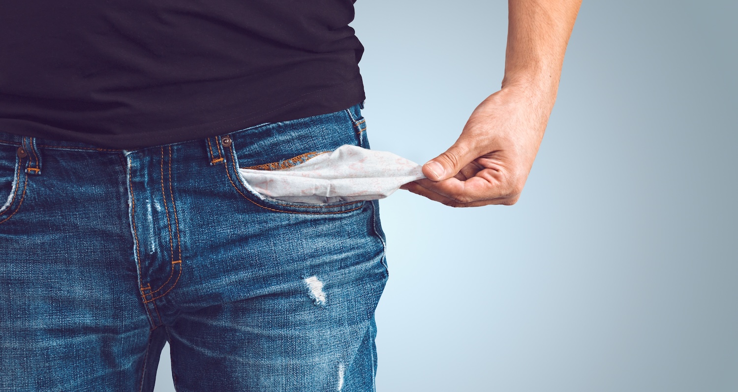 Man turning out empty pocket. Low income is a problem.