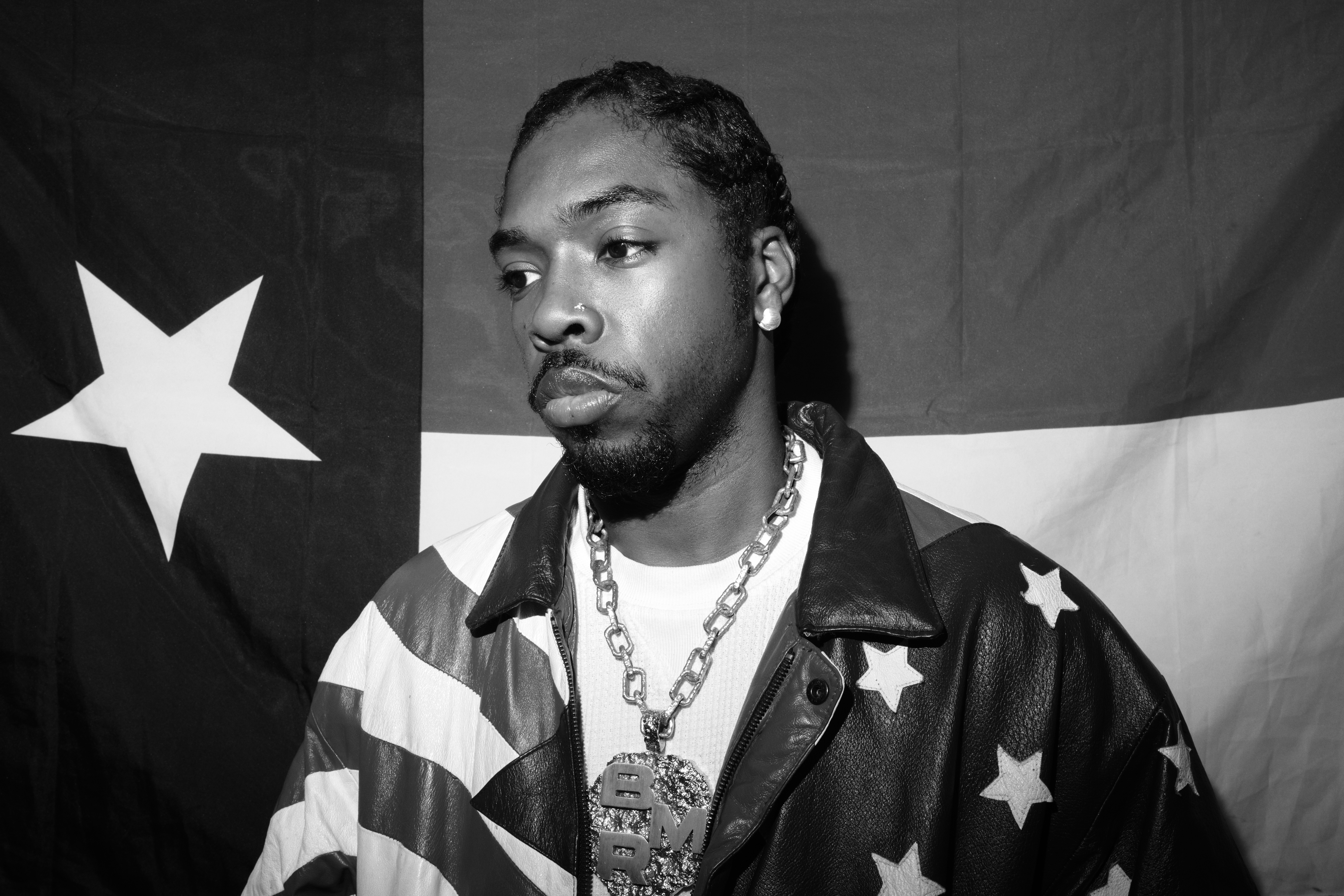 Photo of a man in front of the Texas flag