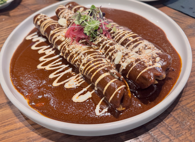 Close up of Milagro tacos cantina chicken taquitos in a mole sauce