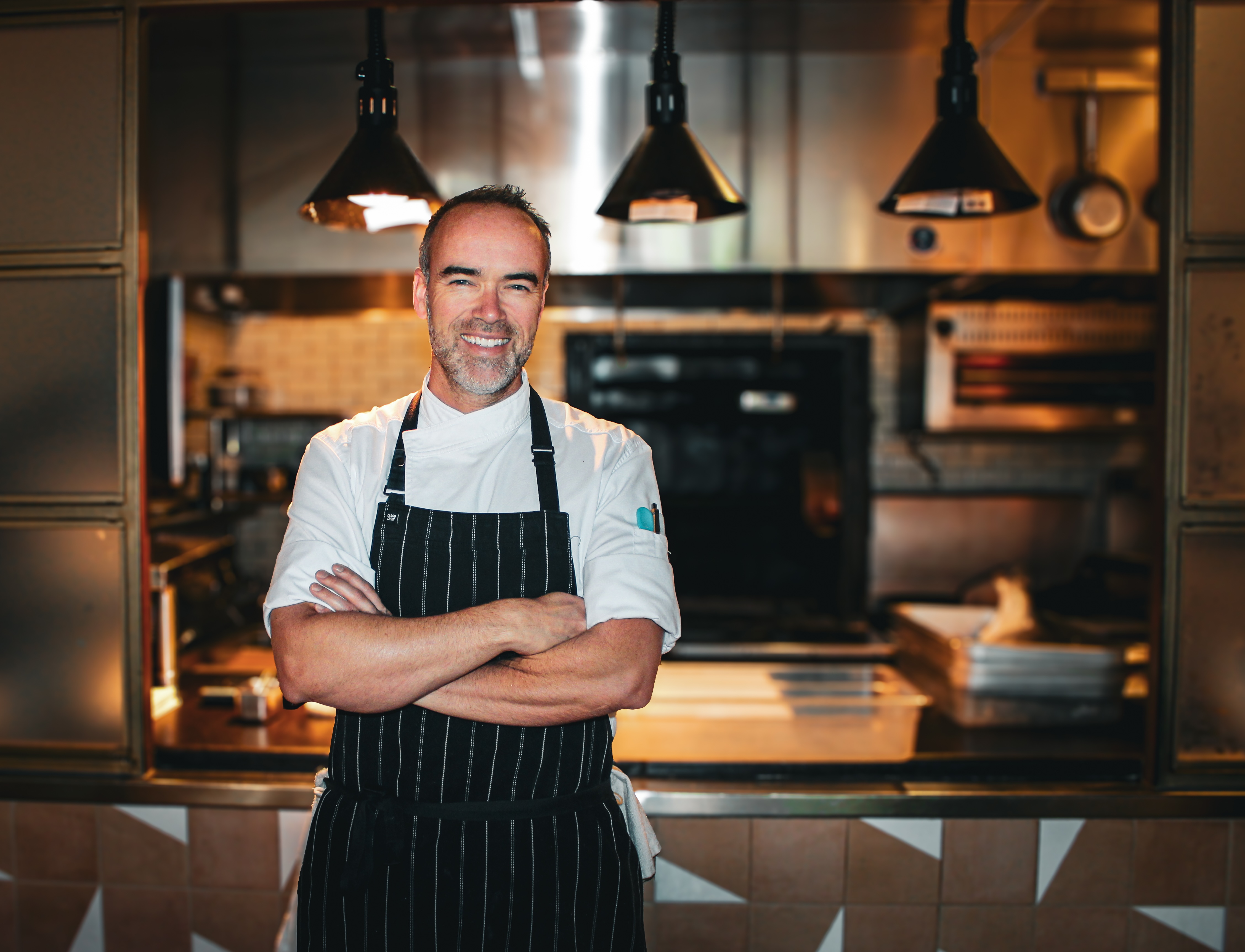 Chef Toby Archibald stands in front of his kitchen at Quarter Acre.