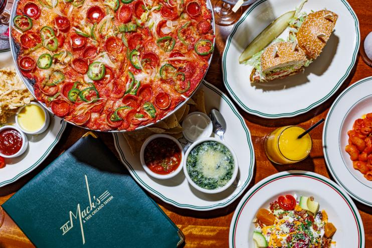 A table at DL Mack's full of some of their signature men items including a sandwich and pizza.