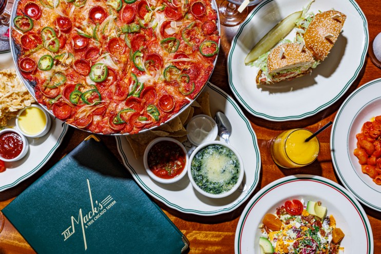 A table at DL Mack's full of some of their signature men items including a sandwich and pizza.