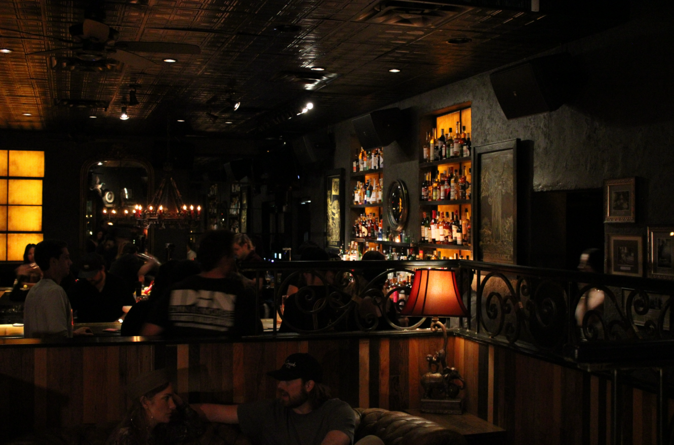 Kilmac's dark exterior livens up with bar backlighting and eclectic light fixtures.