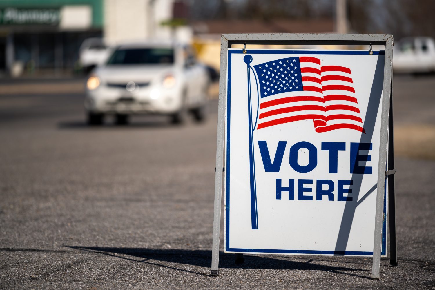 a sign for a voting location with an American flag.