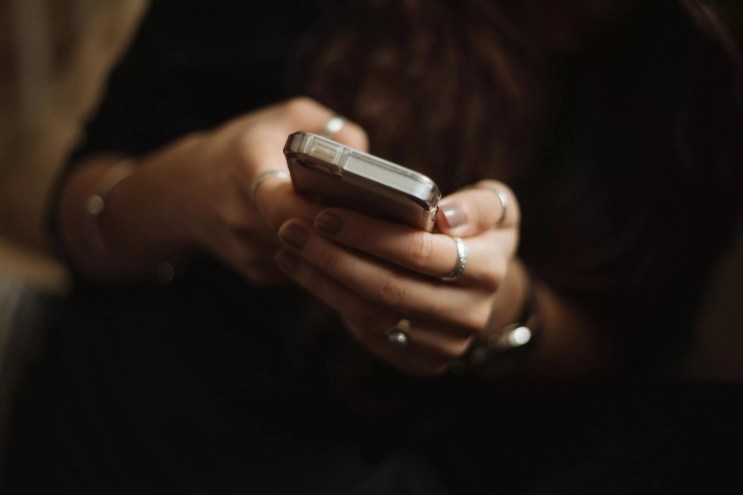 close up on the hands of a person holding a cellphone