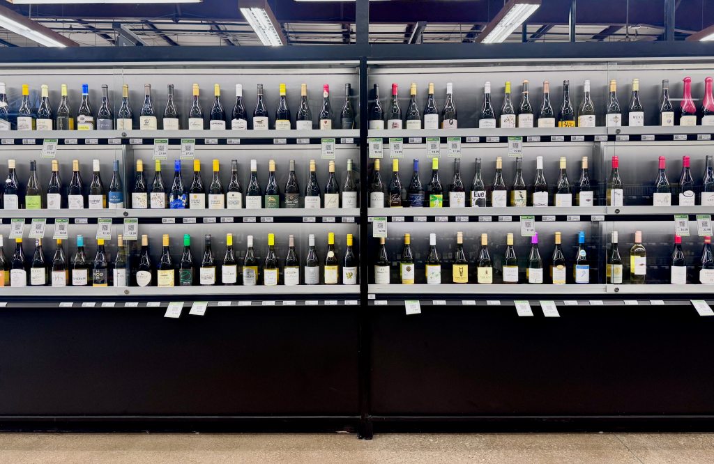Lines of wine behind a glass case at Goody Goody.