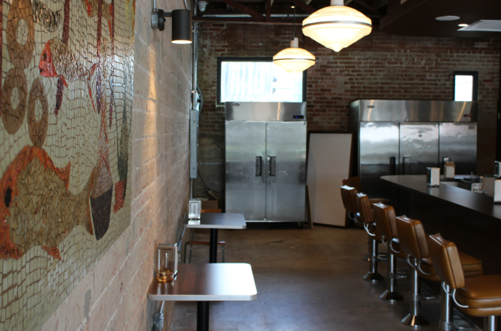 The brick wall of Seegar's with small tables and vinyl sheeting lining the space.