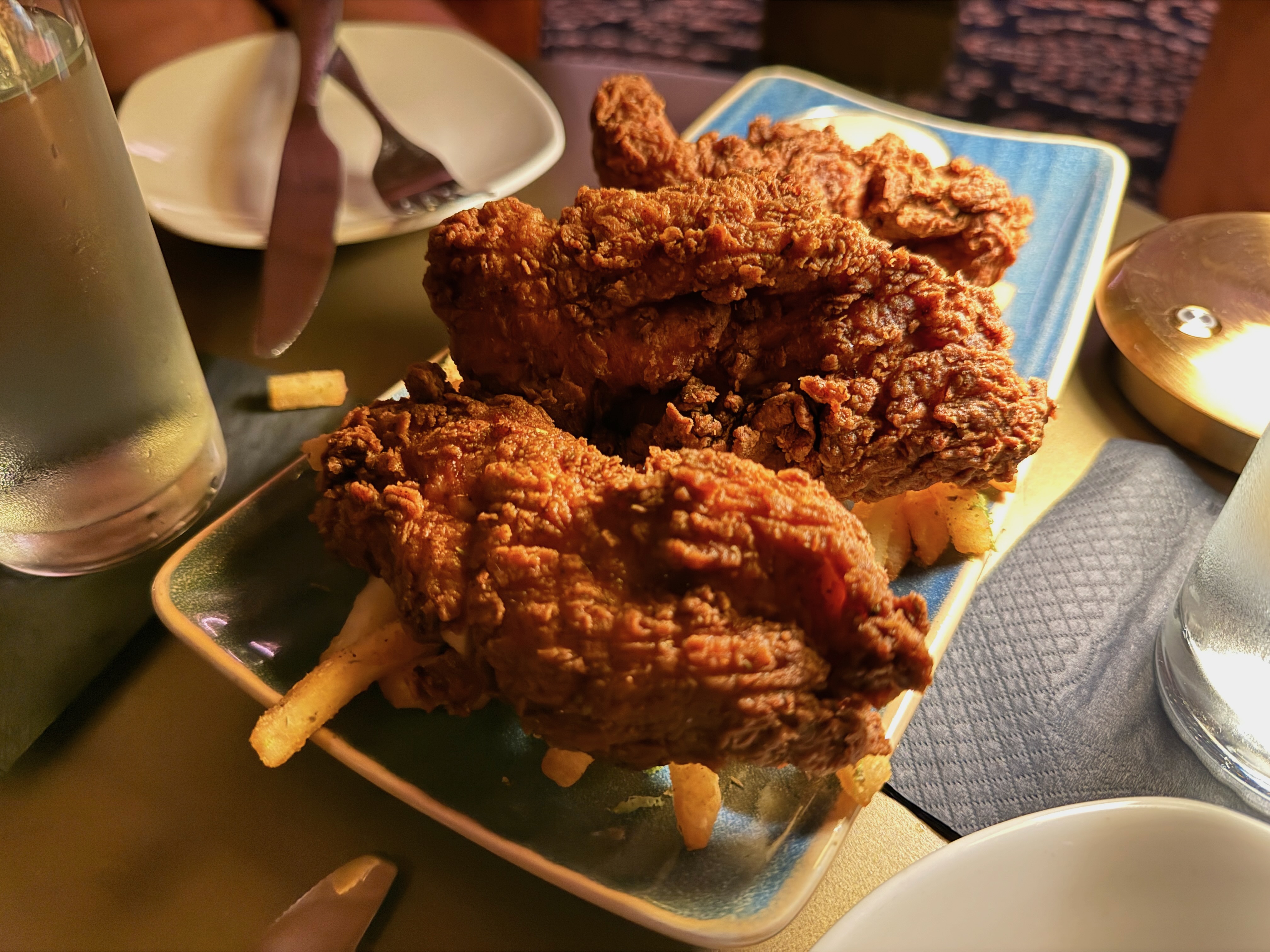 a plate of thick chicken tenders over fries