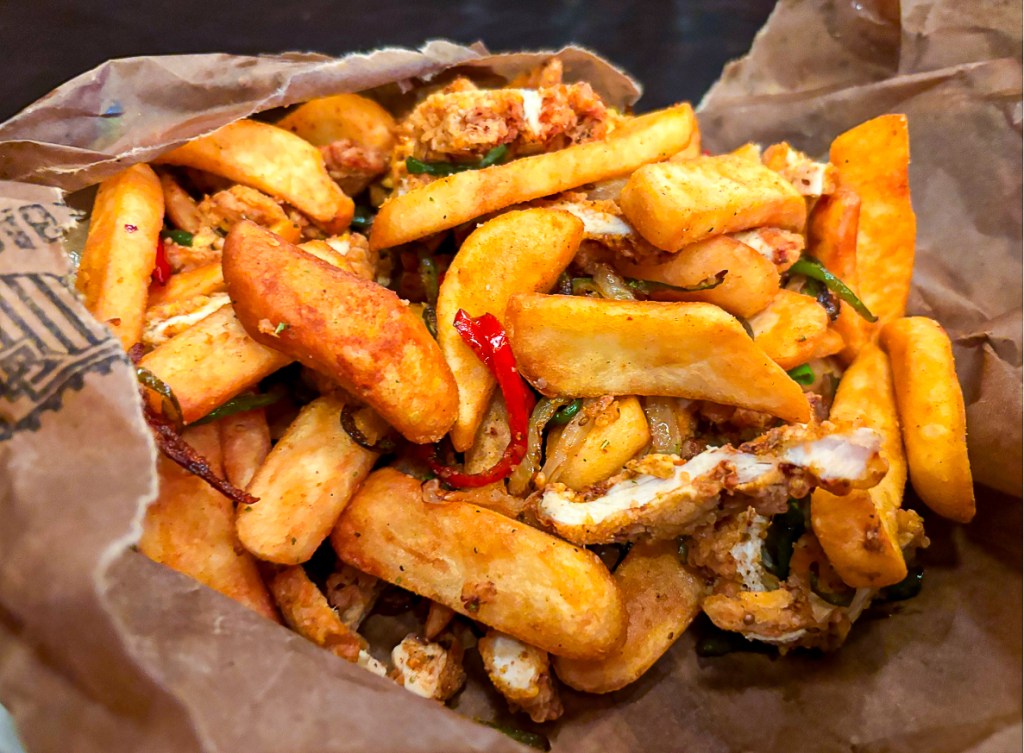a spice bag full of potatoes, chicken and peppers