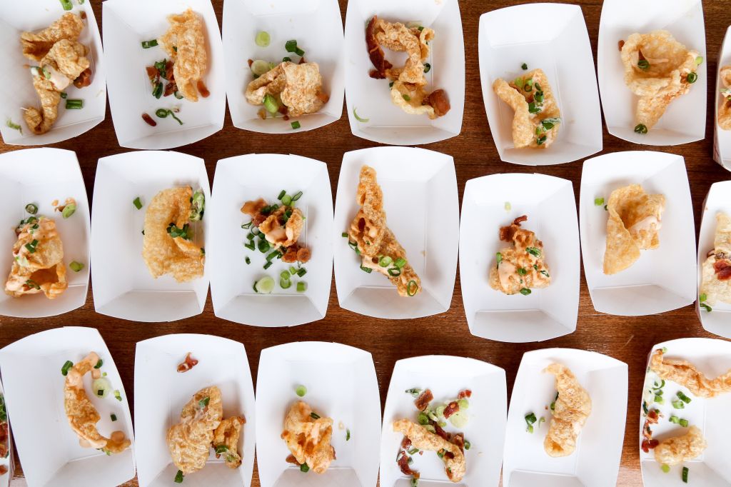a table food of paper boats full of crispy pork rinds