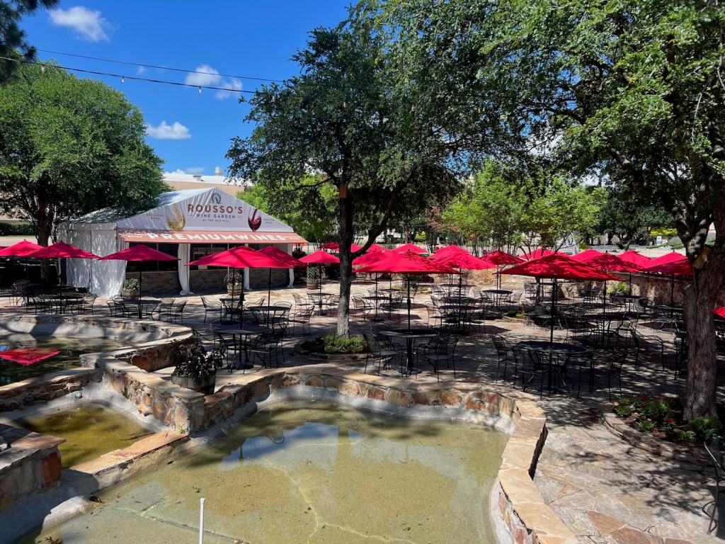 Exterior of Old Mill Inn in Dallas's Fair Park, showing patio and stream