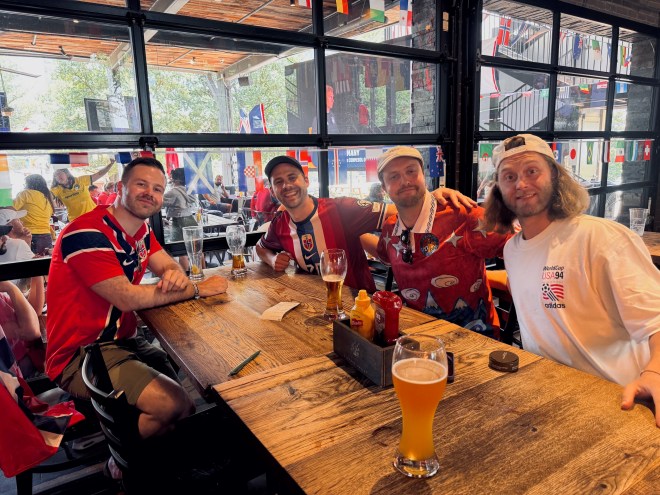 four men sitting at a table in a bar in Dallas