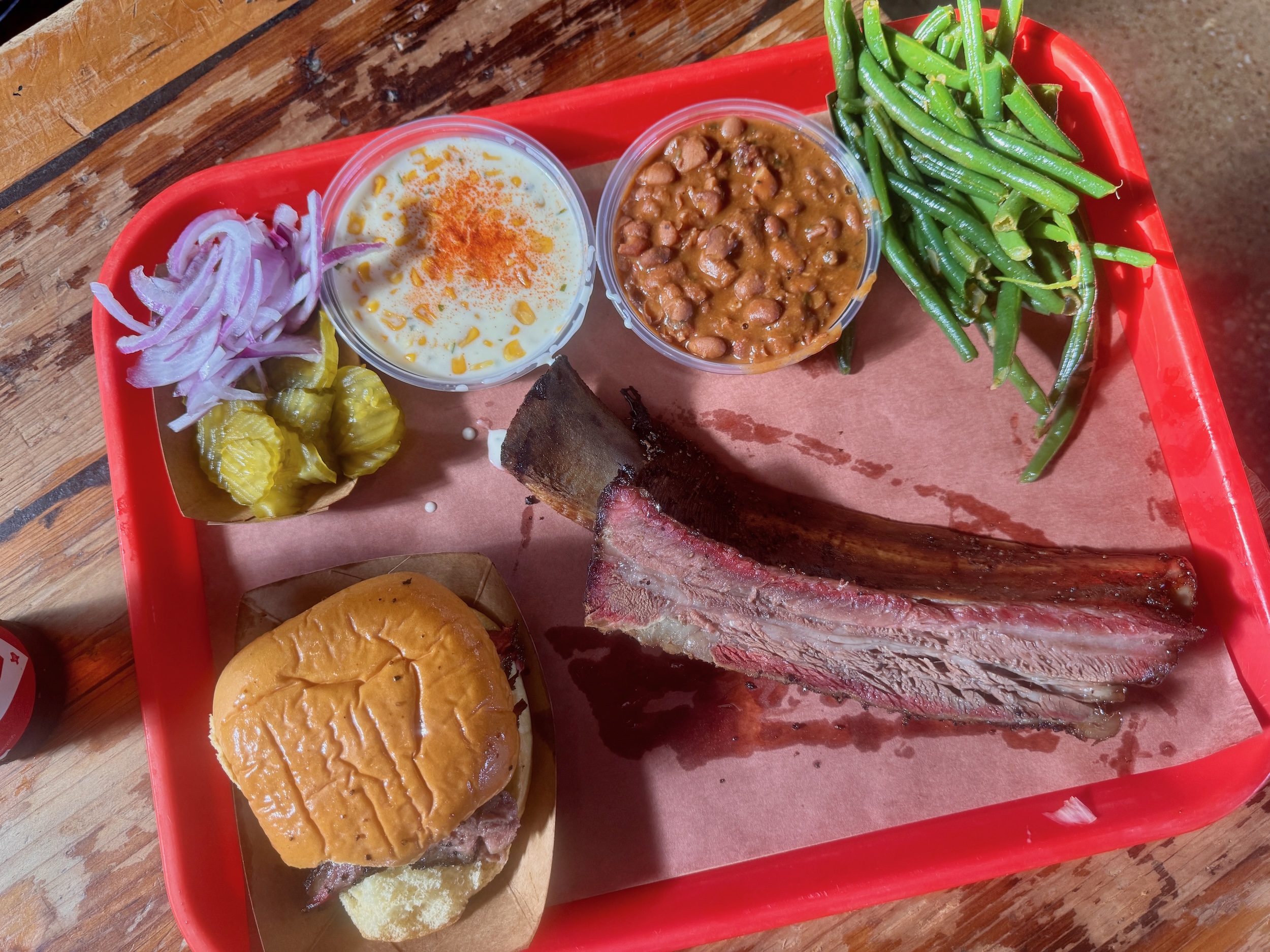 a tray full of food at Terry Black's, including a large beef rib.