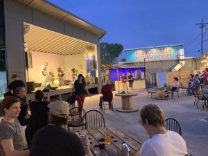 A few people stand in the patio at Rubber Gloves in Denton watching a concert. The venue will no longer tolerate violent most pits.