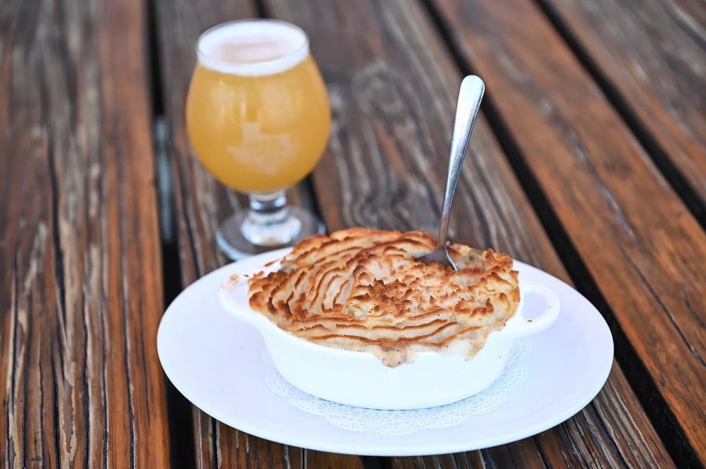 an elegant photo of a beer and Shepherd's pie sitting on a table.  at Lochland's. 