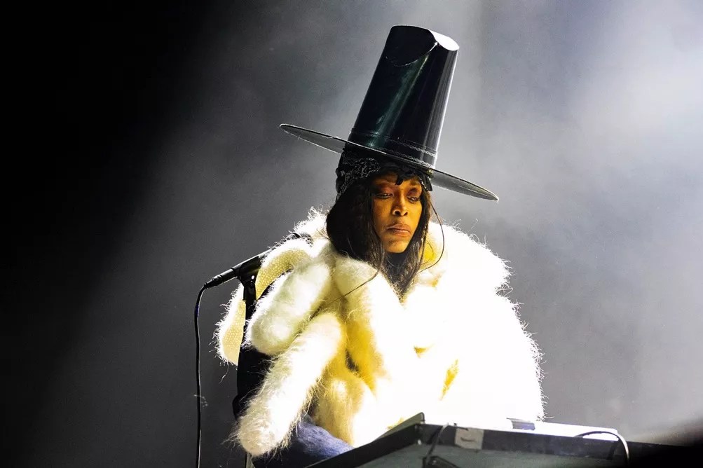 Erykah Badu in a large hat performing in Dallas.