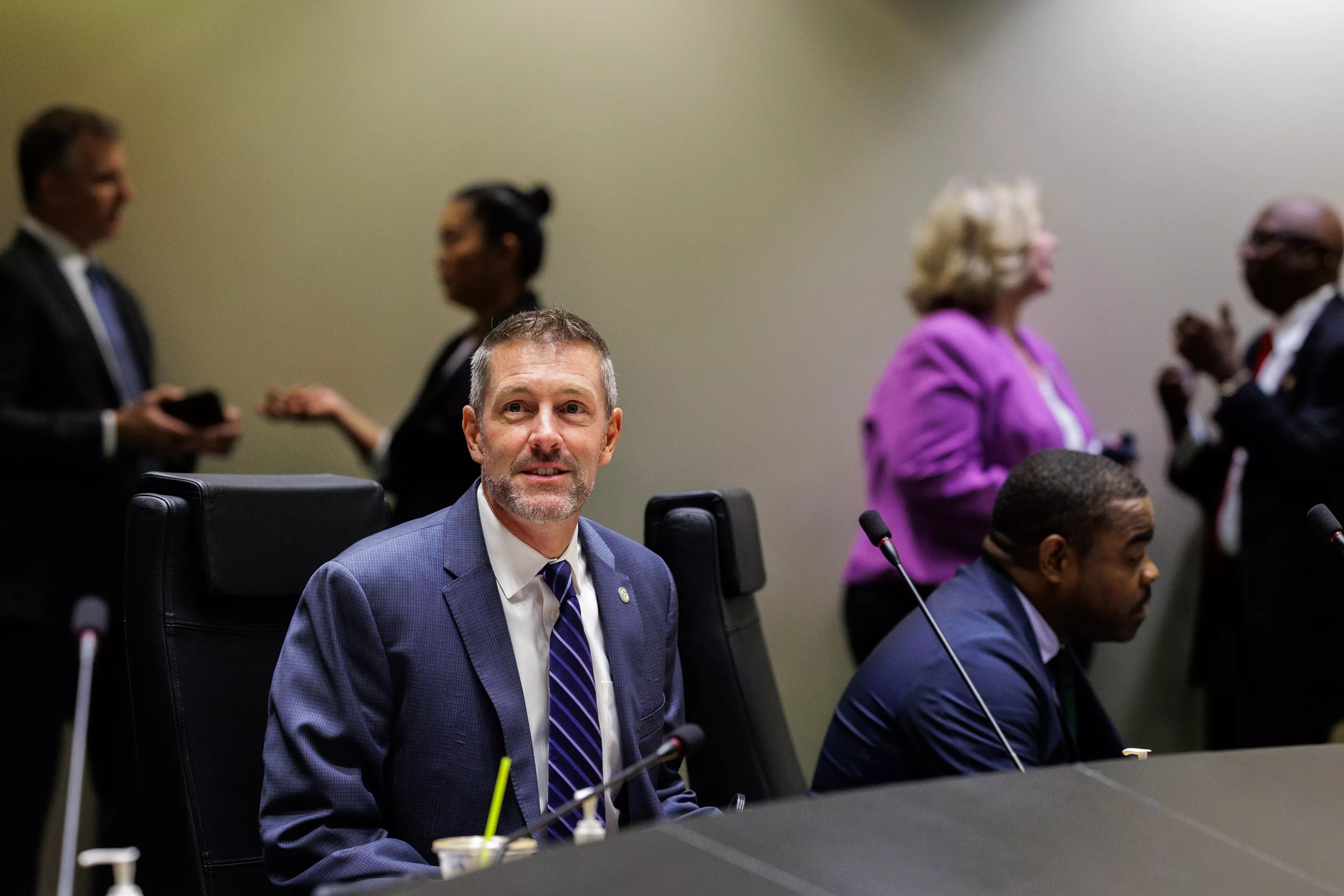 man in a blue suit at a Dallas city council meeting