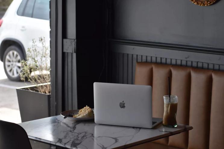 A laptop and cake on a table at B-Side Coffee.