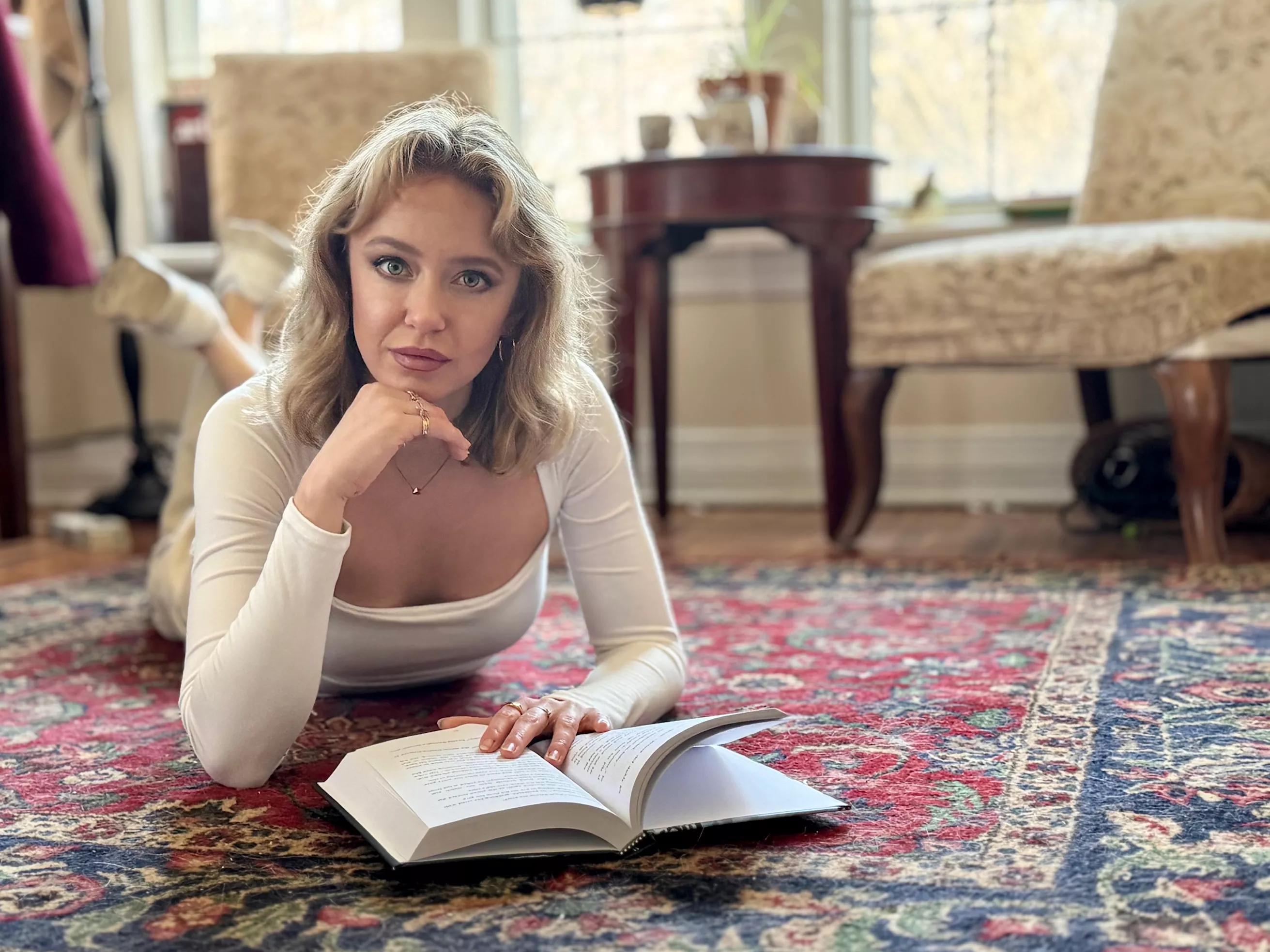 Author Ryann Bee Gordon poses with a book, her trippy new debut novel <i>The Bridge Inside.</i>