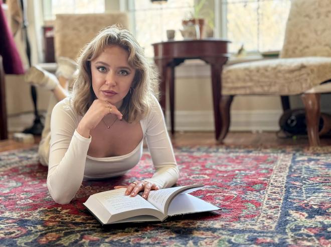 Author Ryann Bee Gordon poses with a book, her trippy new debut novel The Bridge Inside.