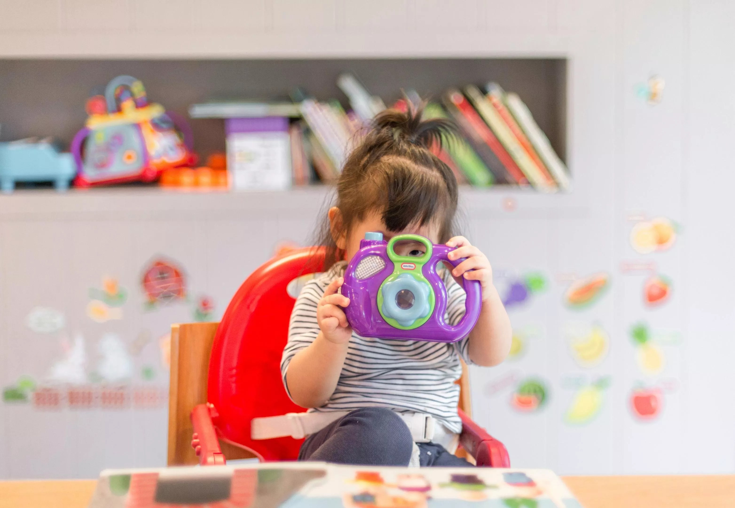 A girl in a daycare class plays with a toy.