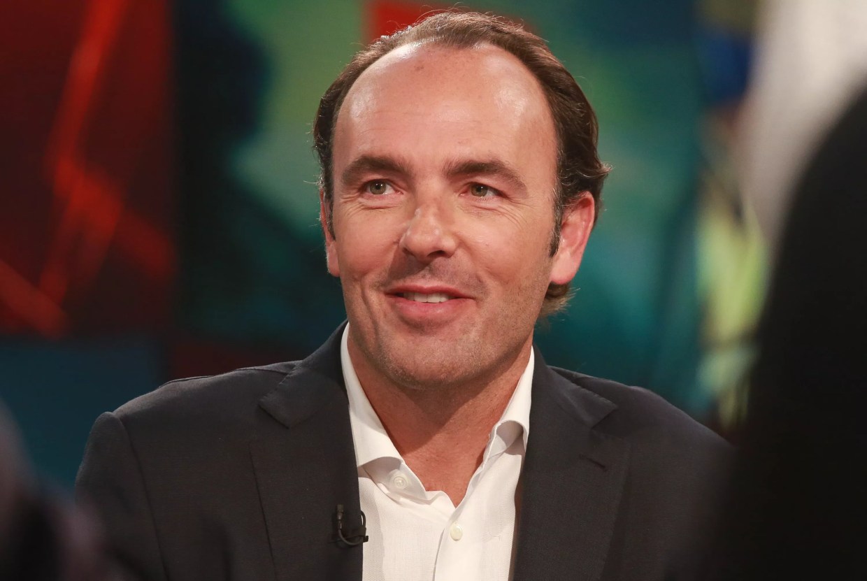 Dallas billionaire Kyle Bass is seen smiling in a suit. This week he became the subject of ridicule after complaining for his room service charges.