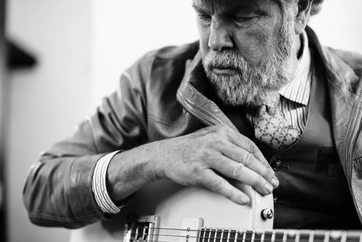 Robert Earl Keen with a guitar.