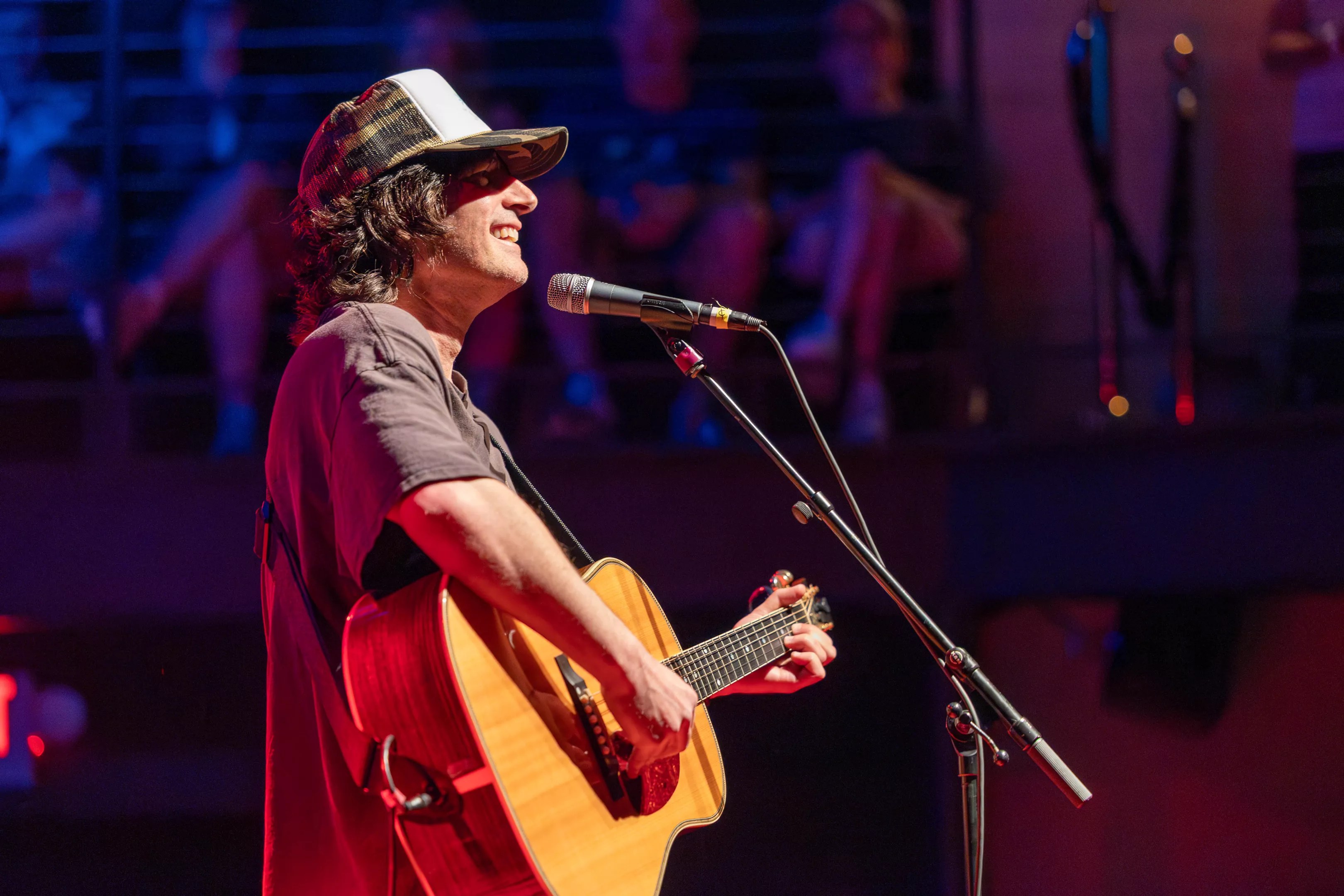 Man performing on stage with a guitar