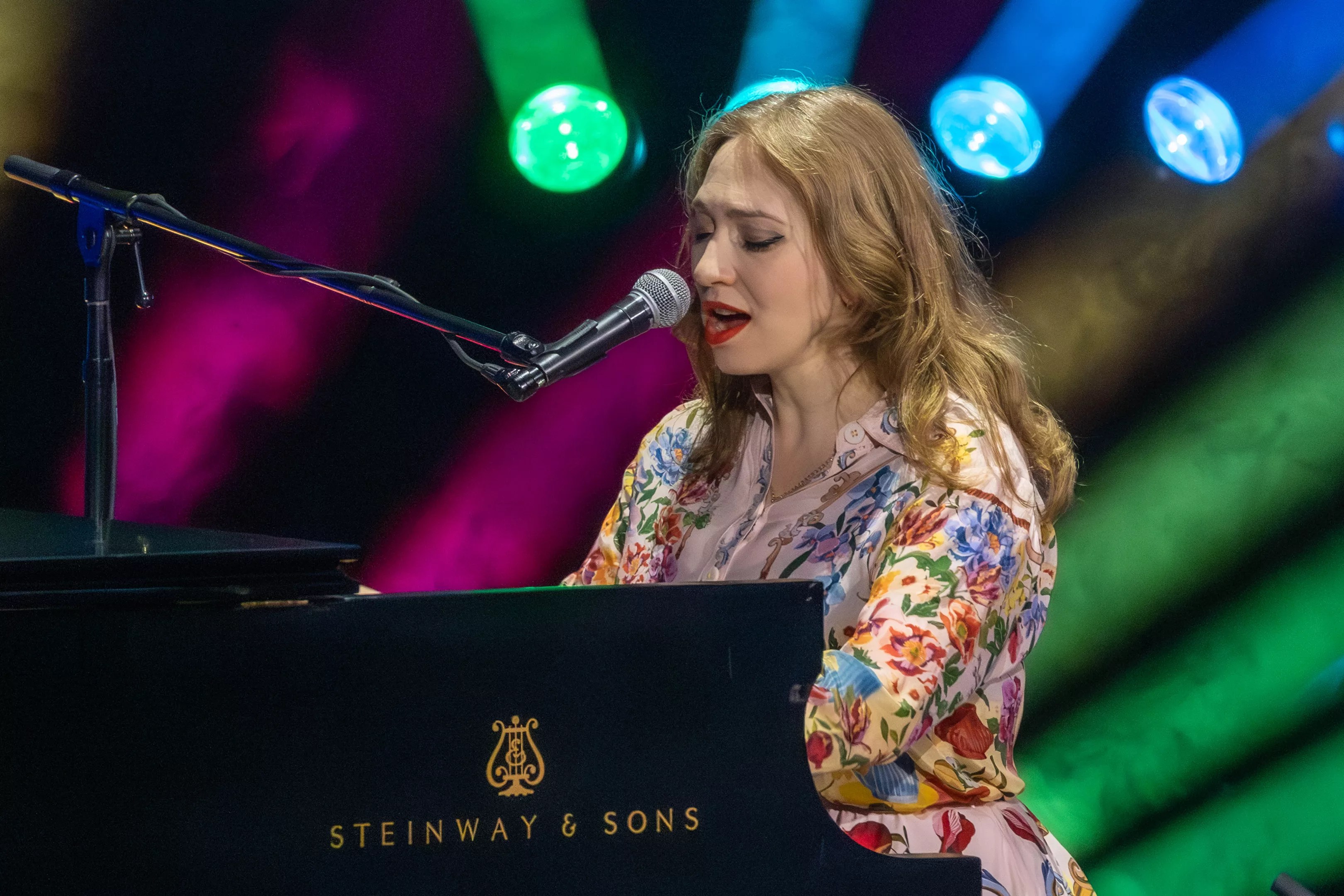 A woman singing on a piano